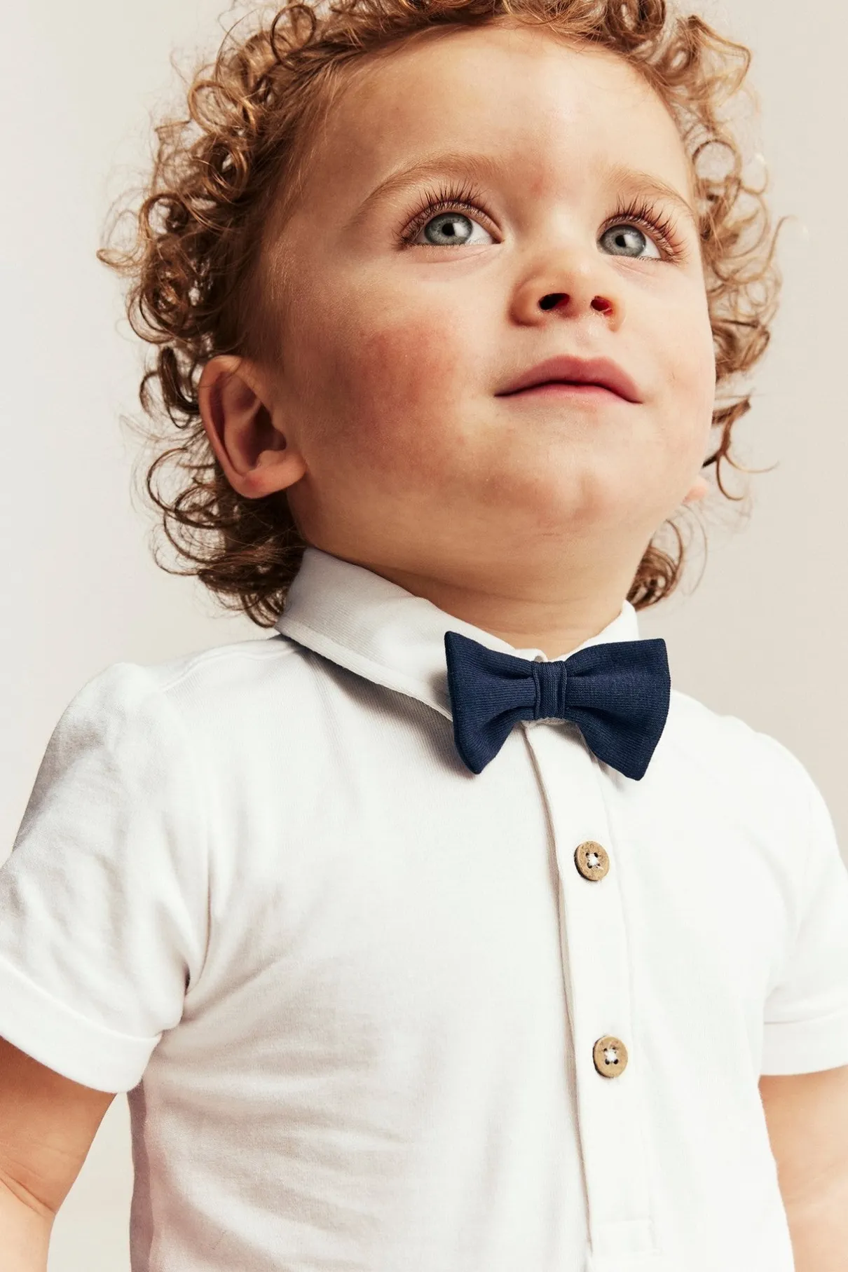 Baby white short-sleeved bodysuit with bow tie